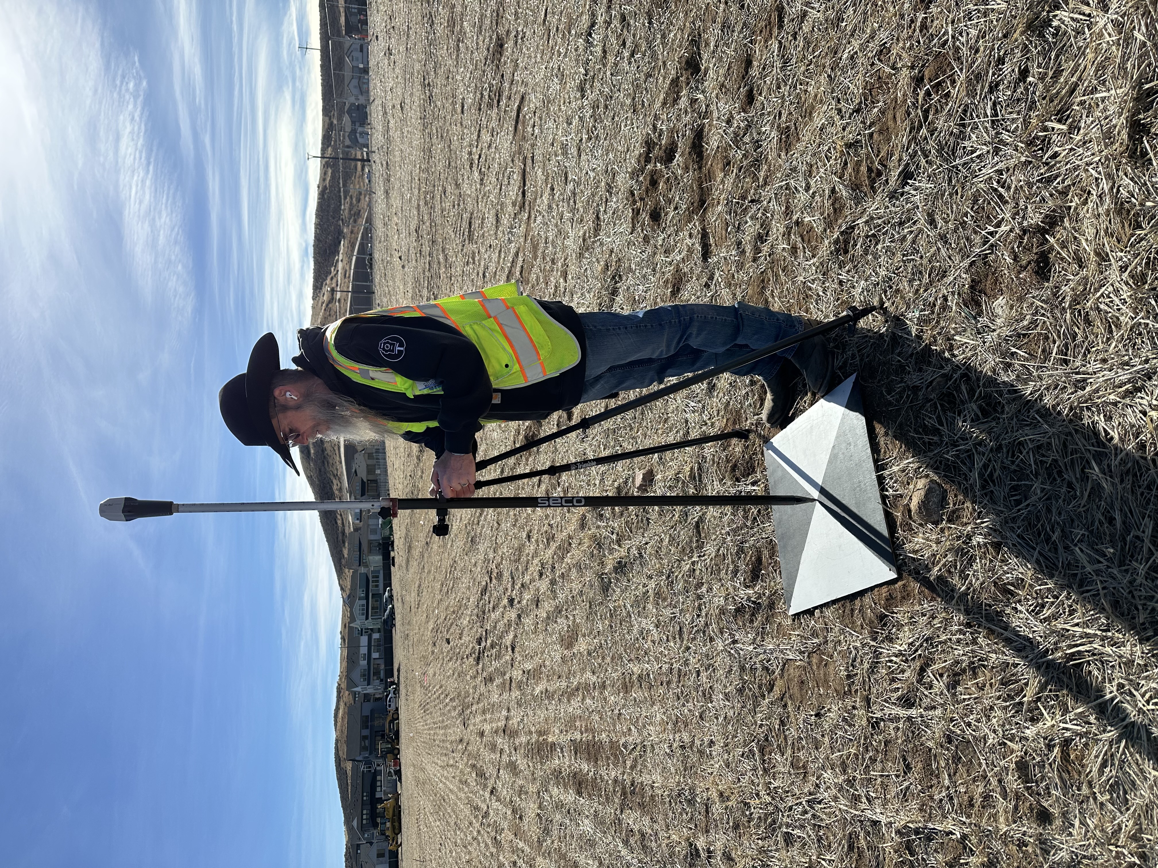 Michael Lilley on a job, shooting a ground control point with his Emlid Reach RX GNSS receiver in a vacant field where the new ES50 school is being built